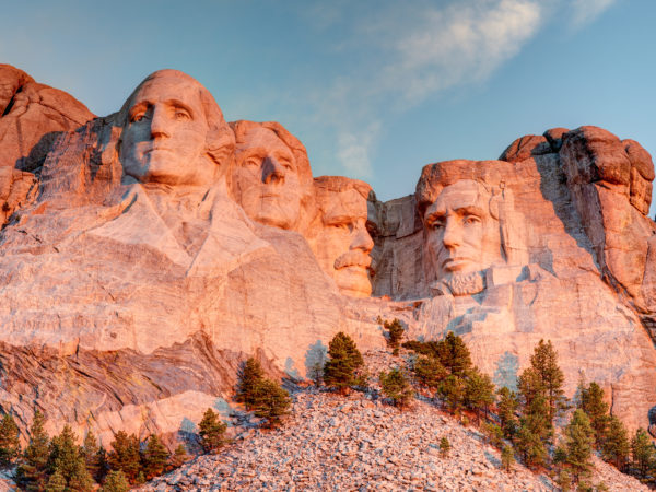 Mount Rushmore National Memorial on a clear blue sunny morning during sunrise showing all four presidents faces in HDR.